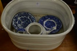 A pottery foot bath and blue and white china.