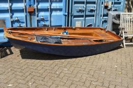 A painted and varnished wooden sailing dingy with accessories.