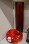 A molded red glass bowl and red glass cylindrical vase.