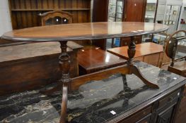 A mahogany oval coffee table with turned supports.