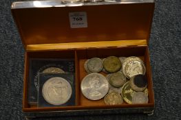 A cigarette box containing a quantity of coins.