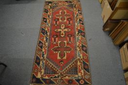 Persian style rug, red ground with geometric decoration 178cm x 78cm.