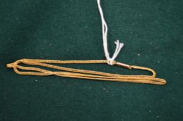 A gold curb link necklace.