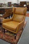 A good pair of modern tan leather upholstered wing armchairs.