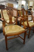 A pair of shield back armchairs with leather upholstered drop-in seats.