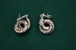 A pair of silver earrings.
