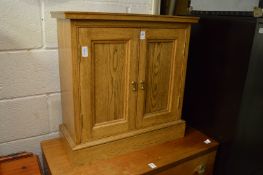 A small oak two door cabinet.