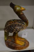 A carved and painted wood model of a bird.