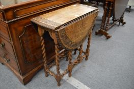 An oak drop-leaf gate-leg barley twist occasional table.