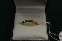 A 9ct gold wedding band, size P.