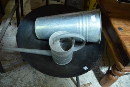 A fire pit, small galvanised watering can and a flower bucket.