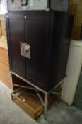 A stylish two door cocktail cabinet on chrome support.