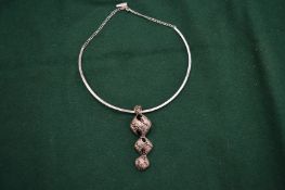 A silver necklace and pendant.