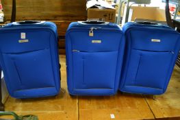 A set of three small light blue suitcases (unused).