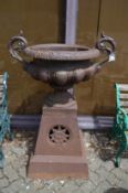 A good large pair of cast iron twin handled urns on pedestal bases.
