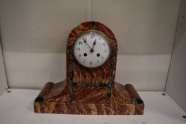 A rouge marble mantel clock.