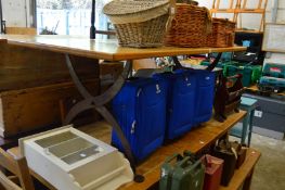 An oak plank top refectory style dining table with wrought iron supports.