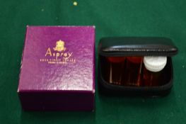 An Asprey box containing a leather pouch with pill boxes.