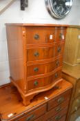 A yew wood small four drawer serpentine fronted chest.