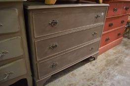 A grey painted three drawer chest.