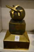 An unusual cast brass model of an aeroplane flying around a globe.