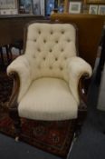 A large Victorian carved mahogany framed button upholstered armchair.