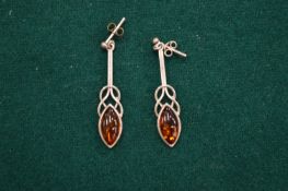 A pair of silver and amber earrings.