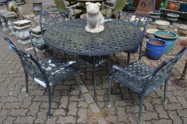 A cast aluminium circular garden table with four matching armchairs.