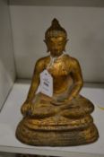 A gilt bronze model of a seated Buddha.