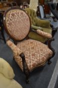 A Victorian carved walnut framed open armchair.