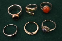 A collection of silver rings, some mounted with gold elements.