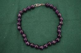 An amethyst bead necklace.