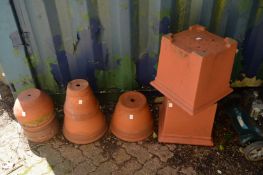 A quantity of terracotta plant pots and a pair of plastic planters.
