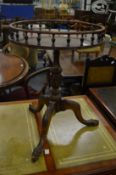 A carved mahogany tripod table with galleried circular top.