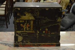 A small Chinese table top cabinet with lacquer decoration, the two doors opening to reveal small