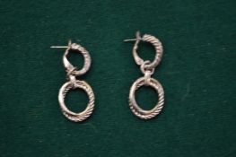 A pair of silver earrings.