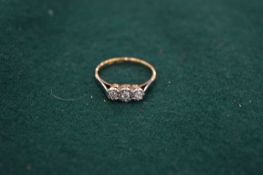 An 18ct gold and platinum diamond three stone ring, size R.