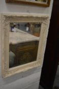 A decorative wall mirror with cream painted frame.