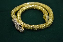 An unusual gold plated snake necklace with crystal head and tail.