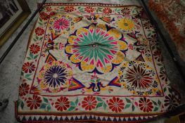 A decorative embroidered throw with applied mirrored design.