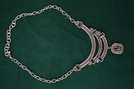 A decorative silver coloured necklace and pendant.