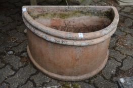 A large pair of terracotta demi-lune planters.