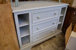 A grey painted kitchen unit with three drawers and storage shelves.