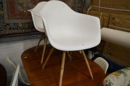 A pair of Vitra Eames DAW style molded plastic armchairs with four similar side chairs.