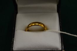 An 18ct gold wedding band, size N.