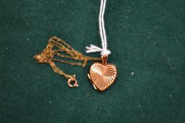 A 9ct gold chain with heart shaped locket.