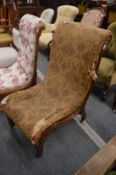 A Victorian rosewood framed slipper style armchair.