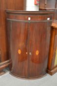 A 19th century mahogany bow front two door hanging corner cupboard.