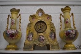 Floral decorated pottery clock garniture.