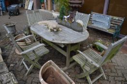 Hardwood extending garden table with a set of four folding armchairs.